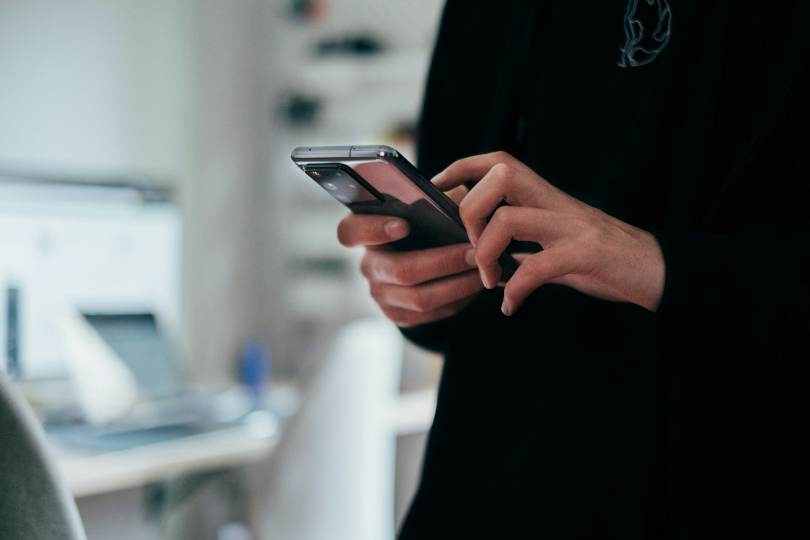 Hands holding a smartphone to reply to a customer enquiry
