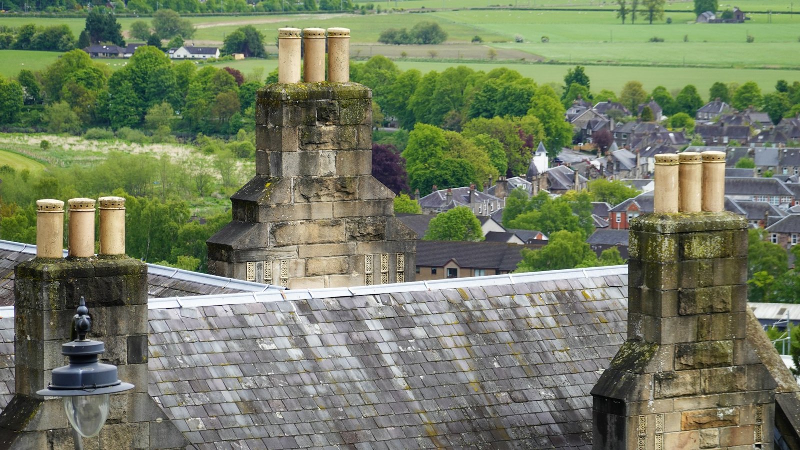 Slate roof and stone chimneys overlooking a UK town